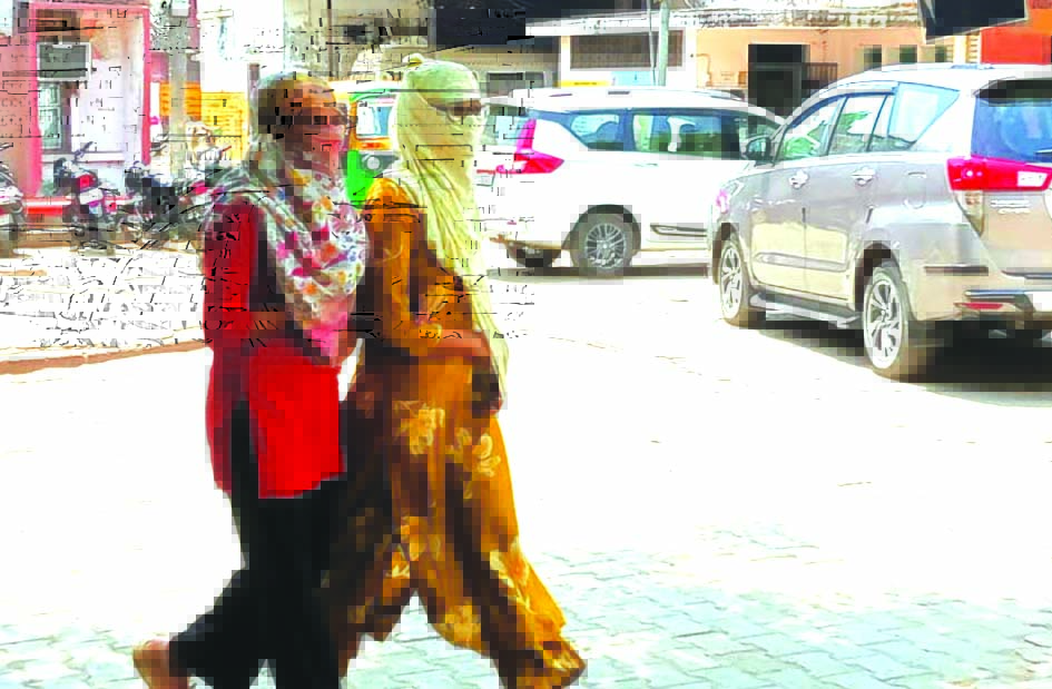 जौनपुर में भीषण गर्मी और लू के बीच लोग चेहरा ढककर बाहर निकलते हुए