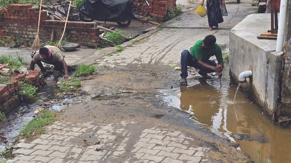 प्रेमराजपुर में जाम नाली की सफाई करते नगर पालिका के सफाईकर्मी