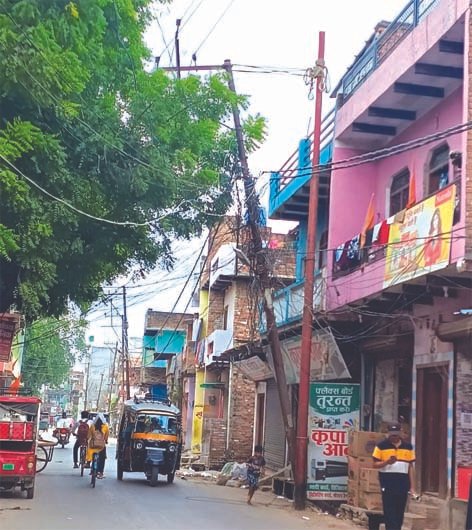 जौनपुर की पुरानी बाजार रोड पर रस्सी के सहारे टिकाया गया जर्जर बिजली पोल